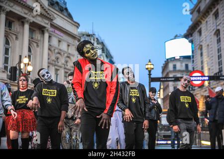 Piccadilly Circus, London, Großbritannien. Oktober 2021. Die Tänzer erstellen die berühmten Zombie-Tanzszenen aus Michael Jacksons „Thriller“-Video neu. Feiernden nehmen an einem Halloween-Tanz-Flashmob Teil, darunter eine Gruppe von Locals.org, einer sozialen Plattform mit Sitz in London, und treffen sich, um Londoners zusammenzubringen. Passanten werden ermutigt, mitzumachen und zu tanzen. Kredit: Imageplotter/Alamy Live Nachrichten Stockfoto