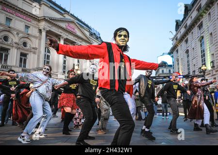 Piccadilly Circus, London, Großbritannien. Oktober 2021. Die Tänzer erstellen die berühmten Zombie-Tanzszenen aus Michael Jacksons „Thriller“-Video neu. Feiernden nehmen an einem Halloween-Tanz-Flashmob Teil, darunter eine Gruppe von Locals.org, einer sozialen Plattform mit Sitz in London, und treffen sich, um Londoners zusammenzubringen. Passanten werden ermutigt, mitzumachen und zu tanzen. Kredit: Imageplotter/Alamy Live Nachrichten Stockfoto