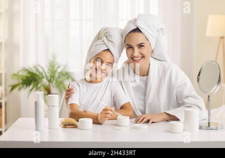 Die junge Mutter und ihre Tochter im Teenageralter organisieren einen Schönheitssalon und verbringen gemeinsam einen Kurtag. Stockfoto