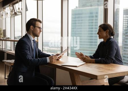 Seriöser HR-Manager, der ein Vorstellungsgespräch mit einem indischen Bewerber führt. Stockfoto