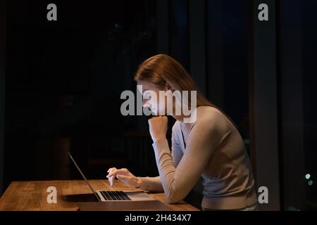Glückliche motivierte junge Geschäftsfrau, die am Computer arbeitet. Stockfoto