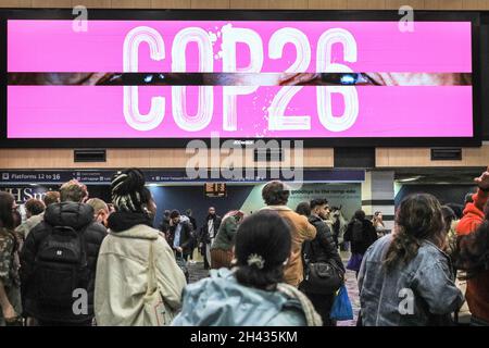 Euston Station, London, Großbritannien. Oktober 2021. In einer überfüllten Euston Station warten die Menschen auf Informationen, da viele Züge nach Glasgow aufgrund früherer wetterbedingter Störungen und eines gefallenen Baumes auf einer Eisenbahnlinie verspätet oder abgesagt wurden. Einige Besucher, Teilnehmer und Delegierte werden möglicherweise mit Verzögerungen auf ihrer Reise zur COP26 konfrontiert. Der Bahnhof ist ein Hauptdrehkreuz für Reisende zum Gipfel und auf den Plakaten werden Meldungen zum Ereignis angezeigt. Kredit: Imageplotter/Alamy Live Nachrichten Stockfoto