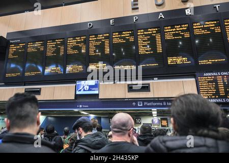 Euston Station, London, Großbritannien. Oktober 2021. In einer überfüllten Euston Station warten die Menschen auf Informationen, da viele Züge nach Glasgow aufgrund früherer wetterbedingter Störungen und eines gefallenen Baumes auf einer Eisenbahnlinie verspätet oder abgesagt wurden. Einige Besucher, Teilnehmer und Delegierte werden möglicherweise mit Verzögerungen auf ihrer Reise zur COP26 konfrontiert. Der Bahnhof ist ein Hauptdrehkreuz für Reisende zum Gipfel und auf den Plakaten werden Meldungen zum Ereignis angezeigt. Kredit: Imageplotter/Alamy Live Nachrichten Stockfoto