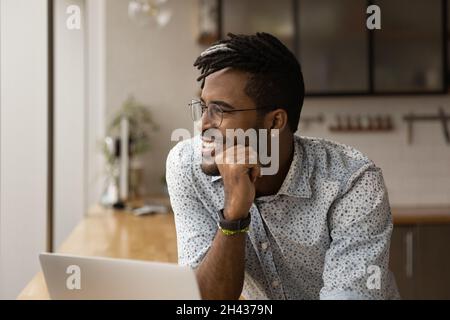 Lächelnder junger, multirassischer Geschäftsmann, der in die Ferne blickt. Stockfoto