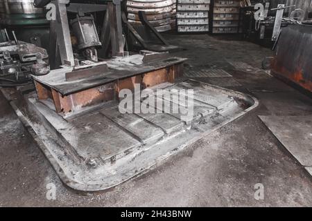 Fräsmaschinenbett, Ausrüstung aus dem Graben für die Kühlmittelentwässerung, schmutzige Produktion in der Werkstatt des Industriewerks. Stockfoto