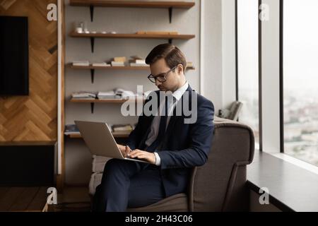 Fokussierter junger männlicher Mitarbeiter, der am Computer arbeitet. Stockfoto
