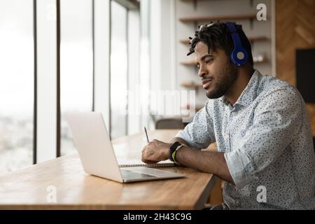 Fokussierter junger afroamerikanischer Mann, der auf Online-Kursen studiert. Stockfoto