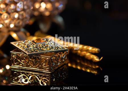 Geschenkbox mit goldenem Kerzenstiel mit und auf reflektierender Basis für Diwali deepawali dipawali lakshmi pooja oder puja, mit glitzerndem Bokeh-Hintergrund Stockfoto