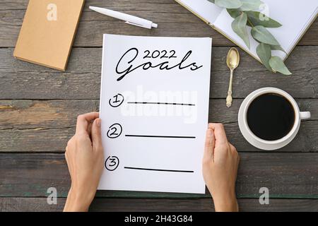 Junge Frau, die eine Liste für 2022 Jahre am Tisch macht Stockfoto