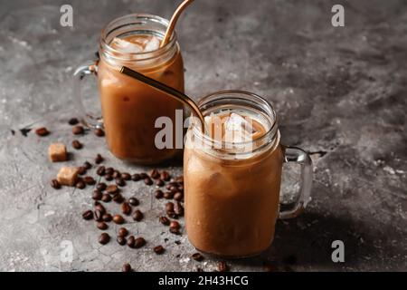 Mason Gläser von leckeren Eiskaffee mit Milch auf grunge Hintergrund Stockfoto
