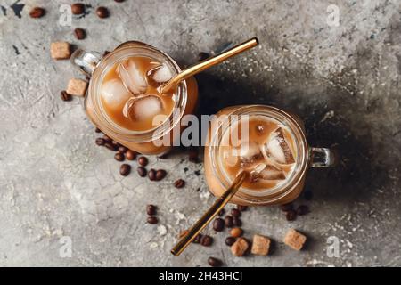 Mason Gläser von leckeren Eiskaffee mit Milch auf grunge Hintergrund Stockfoto