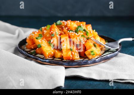 Teller mit Honig-Chilipartoffel auf dem Tisch Stockfoto
