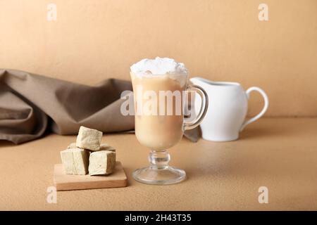 Glas vereisten Hojicha Latte und Würfel auf beigefarbenem Hintergrund Stockfoto