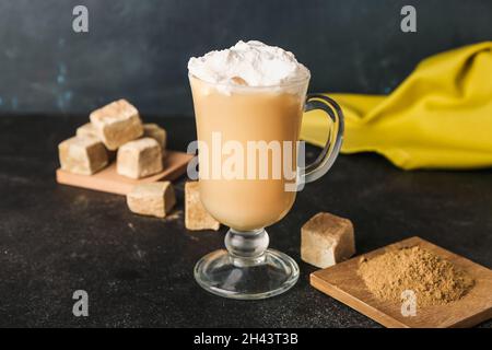 Glastasse aus vereister Hojicha Latte und Pulver auf schwarzem Hintergrund Stockfoto