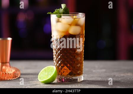 Ein Glas leckeren Cuba Libre Cocktail mit Minze auf dem Tisch in der Bar Stockfoto