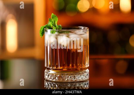 Ein Glas leckeren Cuba Libre Cocktail mit Minze auf dem Tisch in der Bar Stockfoto