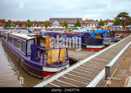 Schmale Boote liegen in Stratford-upon-Avon. In der Ferne ist der geschäftige Markt zu sehen. Stockfoto