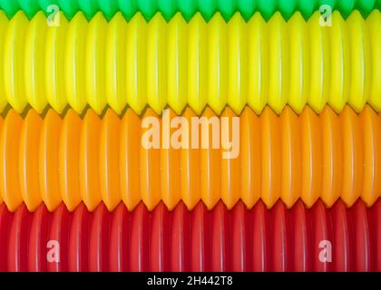 Hintergrund aus bunten Pop-Röhren, neue Fidget Antistress-Spielzeug. Stockfoto