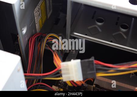 Man hält einen molex-Stecker und eine Buchse an den Enden der Buchsen und verbindet sie in einem Stück, damit der Computer wieder funktioniert. Stockfoto