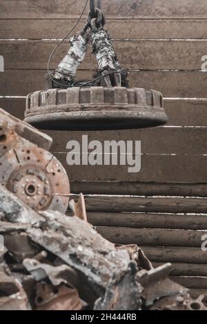 Magnetschrottkran recycelt und entlädt Müll und altes Metall auf einer Deponie. Stockfoto