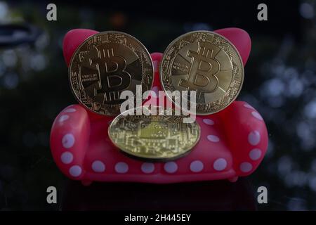 Einige Bitcoins sitzen auf einer weißen gepunkteten roten Spielzeugcouch. Geld und Geschäft trösten. Stockfoto