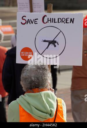 Eine ältere Frau hält ein Schild bei einer Protestkundgebung mit der Aufschrift „Rettet Kinder. Wir können Waffengewalt beenden.“ Stockfoto