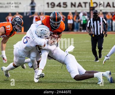 Stillwater, Oklahoma, USA. Oktober 2021. Oklahoma State Cowboys Quarterback Spencer Sanders (3) läuft den Fußball durch zwei Kansas Jayhawk Verteidiger während des Spiels am Samstag, 30. Oktober 2021 im Boone Pickens Stadium in Stillwater, Oklahoma. (Bild: © Nichola Rutledge/ZUMA Press Wire) Stockfoto