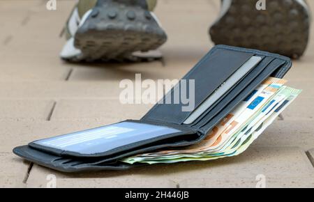 Verlorene Brieftasche, mit Banknoten liegt auf der Straße Stockfoto