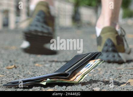 Verlorene Brieftasche, mit Banknoten liegt auf der Straße Stockfoto