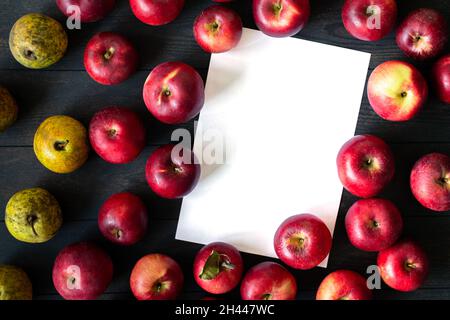 Unperfekte rote Äpfel und gelbe Birnen auf dunklem Hintergrund. Masse. Draufsicht. Isoliert. Saisonale Äpfel. Russland, Tschechow. Stockfoto