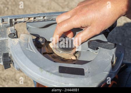 Ein Mann installiert eine Unterlegscheibe, um ein Kreissägeblatt für die Holzbearbeitung zu sichern. Stockfoto