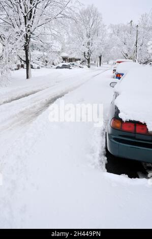 Die Nachwirkungen eines Schneesturms auf einer Wohnstraße. Stockfoto