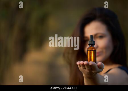Eine glückliche Frau, die eine Flasche Nahrungsergänzungsmittel oder Vitamine in den Händen hält. Das Konzept eines gesunden Lebensstils Stockfoto