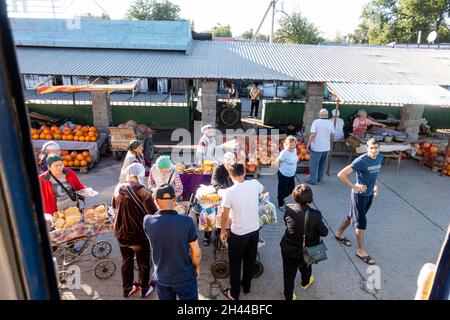Die Händler verkaufen Melonen und Kürbisse an Passagiere auf einem Bahnstoppmarkt in Turkistan, Kasachstan, Zentral- und Asien. Blick vom Zug. Stockfoto