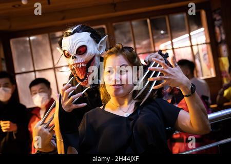 Hongkong, China. Oktober 2021. Eine Frau posiert während der Halloween-Feier mit einem Zombie für Fotos. (Foto von Alex Chan Tsz Yuk/SOPA Images/Sipa USA) Quelle: SIPA USA/Alamy Live News Stockfoto