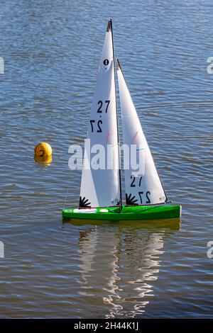 Modellyacht mit einem grünen Rumpf, der sich während eines Rennens in Steveston, British Columbia, Kanada, um eine Markerbouy dreht Stockfoto