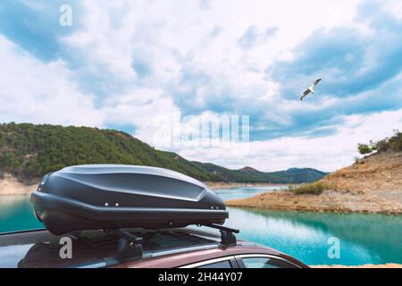 Dachbox für das Auto. Fahrzeugdach mit Kofferraum. Auto mit Gepäckcontainer auf dem Dach. Autofahrten Stockfoto