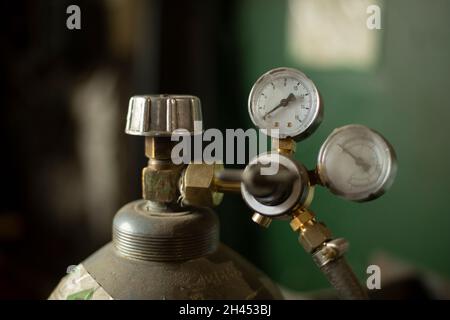 Hochdruckzylinder. Tank mit Gas. Ventil zur Druckeinstellung. Gasflasche in der Garage. Stockfoto