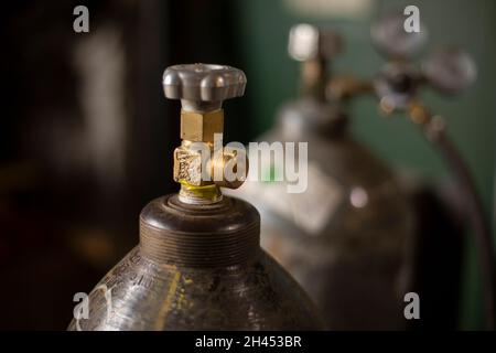 Hochdruckzylinder. Tank mit Gas. Ventil zur Druckeinstellung. Gasflasche in der Garage. Stockfoto