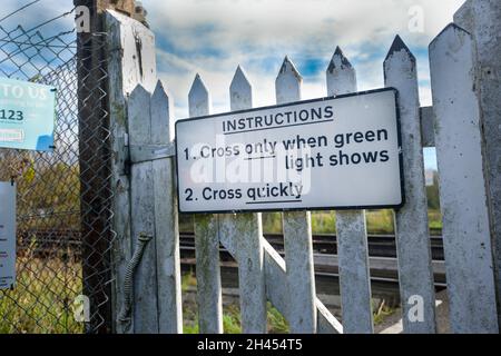 Eisenbahnübergang Fußgängerwarnschild, das darauf hinweist, wann es sicher zu überqueren ist Stockfoto