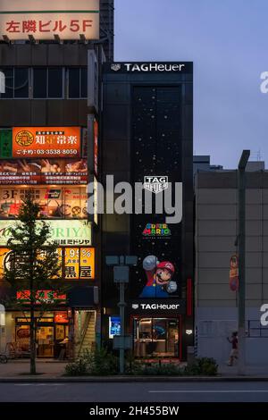 tokio, japan - 24 2021. august: Beleuchtete Schilder an der Fassade der TAG Heuer Ginza Boutique, geschmückt mit dem international bekannten Nintendo-Spiel c Stockfoto