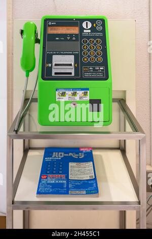 tokio, japan - 24 2021. august: Grünes NTT-öffentliches Telefon und ein Telefonverzeichnis an einer Telefonzelle werden von der japanischen Regierung trotz spr Stockfoto