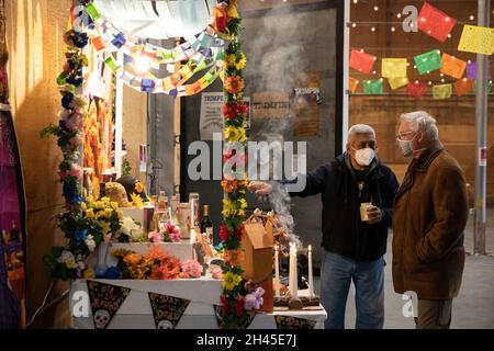 Tieton, Washington, USA. Oktober 2021. Raúl Sánchez (links) zeigt den Altar, den er am Sonntag, den 31. Oktober 2021, bei der Gemeindefest Dia de los Muertos in Tieton, Washington, geschaffen hat. Die jährliche Feier findet in Tieton Arts & Humanities statt, um an verstorbene Freunde und Familienmitglieder zu erinnern und ihre spirituelle Reise zu unterstützen. Quelle: Paul Christian Gordon/Alamy Live News Stockfoto