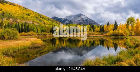 Die sonnenbeschienenen Herbstfarben spiegeln sich im Warner Lake im Manti-La Sal National Forest unterhalb des Haystack Mountain in der Nähe von Moab, Utah, wider. Stockfoto