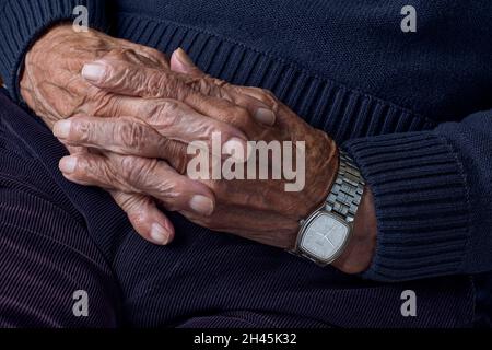 Nahaufnahme der Hände des älteren Mannes, die die Finger kreuzen Stockfoto