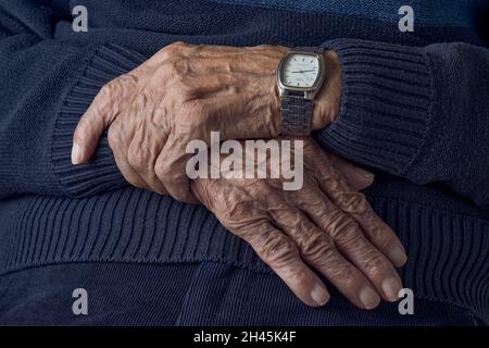 Nahaufnahme der Hände des älteren Mannes, die die Finger kreuzen Stockfoto