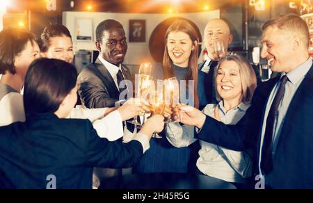 Internationale Gruppe von Geschäftsleuten, die mit Champagner toasten, h Stockfoto