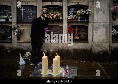 Pamplona, Spanien. Oktober 2021. Eine Frau legt Blumen in die Nische ihres relativen Kolbariums auf dem Friedhof von Pamplona.Anlässlich des Allerheiligen-Tages gehen katholische Familien zum spanischen Berichitos-Friedhof in Pamplona, um Blumen auf die Gräber ihrer verstorbenen Verwandten in Navarra zu legen. Kredit: SOPA Images Limited/Alamy Live Nachrichten Stockfoto