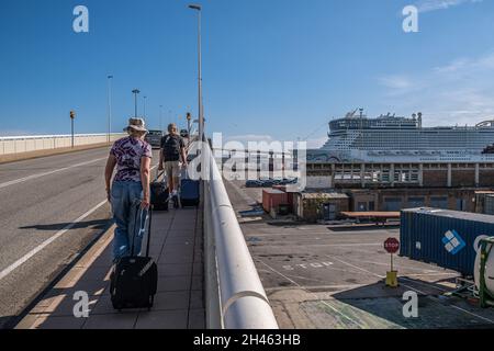 Barcelona, Spanien. Oktober 2021. Passagiere mit Aktentaschen kommen zu Fuß am Kreuzfahrtterminal in Barcelona an.große Touristenkreuzfahrten mit einer Kapazität von mehr als 6,000 Passagieren verkehren täglich im Hafen von Barcelona für Kreuzfahrten im Mittelmeer. Kredit: SOPA Images Limited/Alamy Live Nachrichten Stockfoto