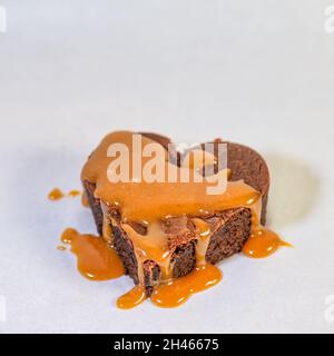 Herzförmiger Schokoladenkuchen mit köstlicher Karamellsauce Stockfoto